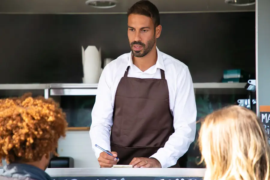 A food truck counter with the owner writing an order — a stock photograph illustrating the scenario.